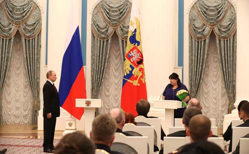 Президент РФ Владимир Путин вручает внучке Александра Печерского орден Мужества, которым ее дед был награжден посмертно. Источник: wikimedia.org