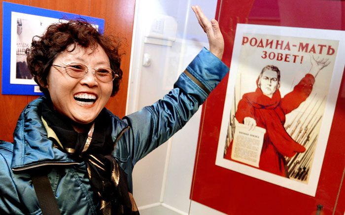 Даже страшно представить, что мог рассказать лже-гид этой тёте о знаменитом плакате, раз она так развеселилась